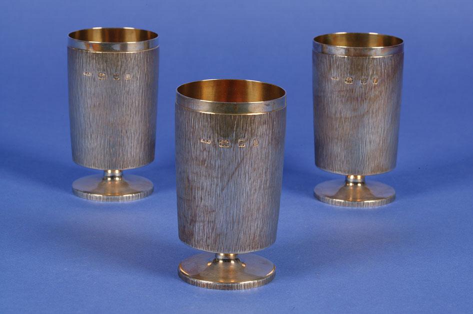 Appraisal: GERALD BENNEY A SET OF THREE GOBLETS of cylindrical form