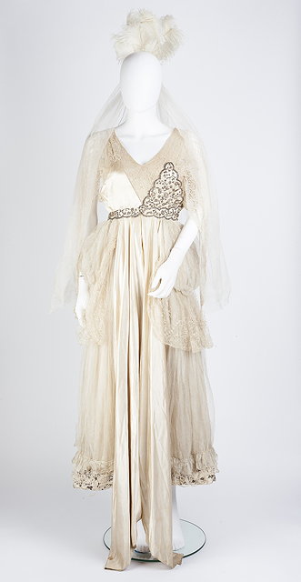 Appraisal: An Edwardian cream satin court dress with lace bodice insert