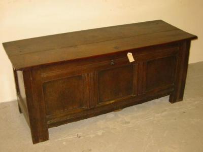 Appraisal: AN OAK PANELLED COFFER with hinged plank lid the fascia