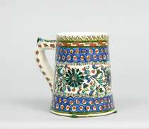 Appraisal: Pottery Tankard Possibly Iznik This Persian tankard features floral and