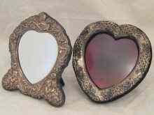 Appraisal: A strut back heart shaped bevelled mirror the silver frame