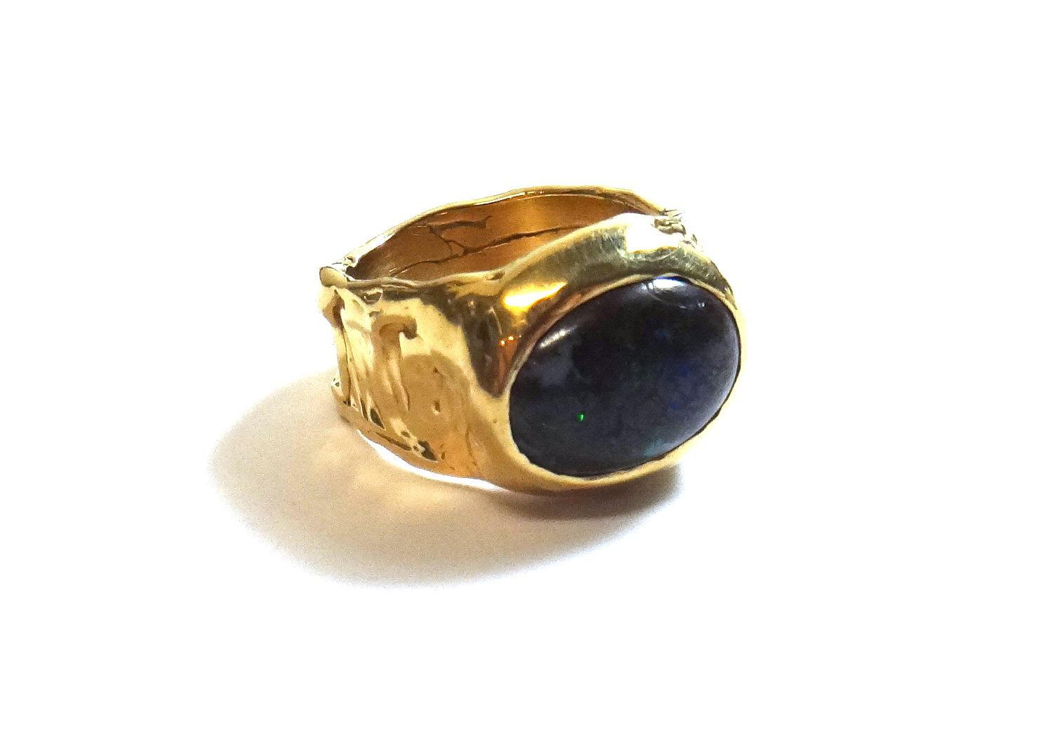 Appraisal: A gold ring mounted with an oval wood opal detailed