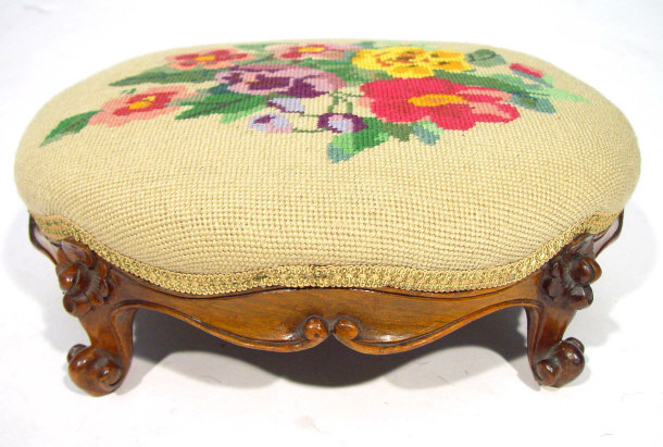 Appraisal: Oval walnut framed footstool with carved claw feet and floral