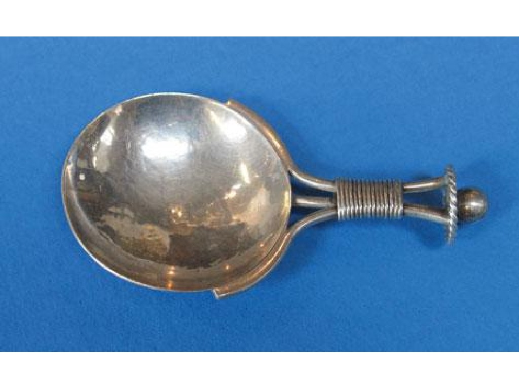 Appraisal: A E JONES A CADDY SPOON the bifurcated handle terminating