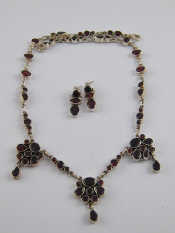 Appraisal: A white metal tests silver garnet necklace with matching earrings