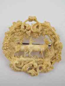 Appraisal: A finely carved ivory brooch depicting deer in woodland surrounded