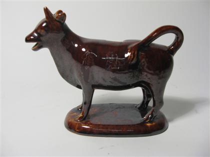 Appraisal: Brown glazed cow creamer H in Descriptions provided in both