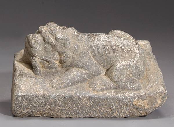 Appraisal: A carved stone recumbent lion rising from a stone base