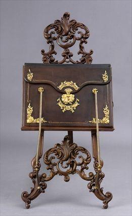 Appraisal: ROCOCO-STYLE CARVED OAK EASEL APPLIED WITH GILT-METAL MOUNTED LEATHER PORTFOLIO