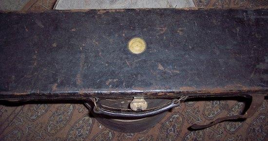 Appraisal: A leather gun case the lid with circular brass label