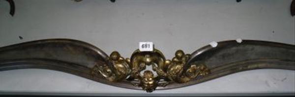 Appraisal: A serpentine shaped steel fender with gilt brass cherubic and