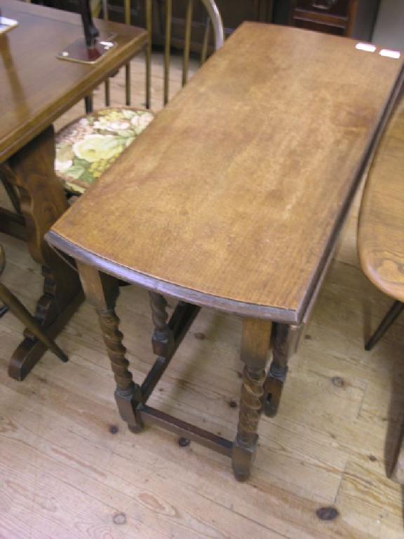 Appraisal: A solid oak gate-leg table on barley twist underframe ft