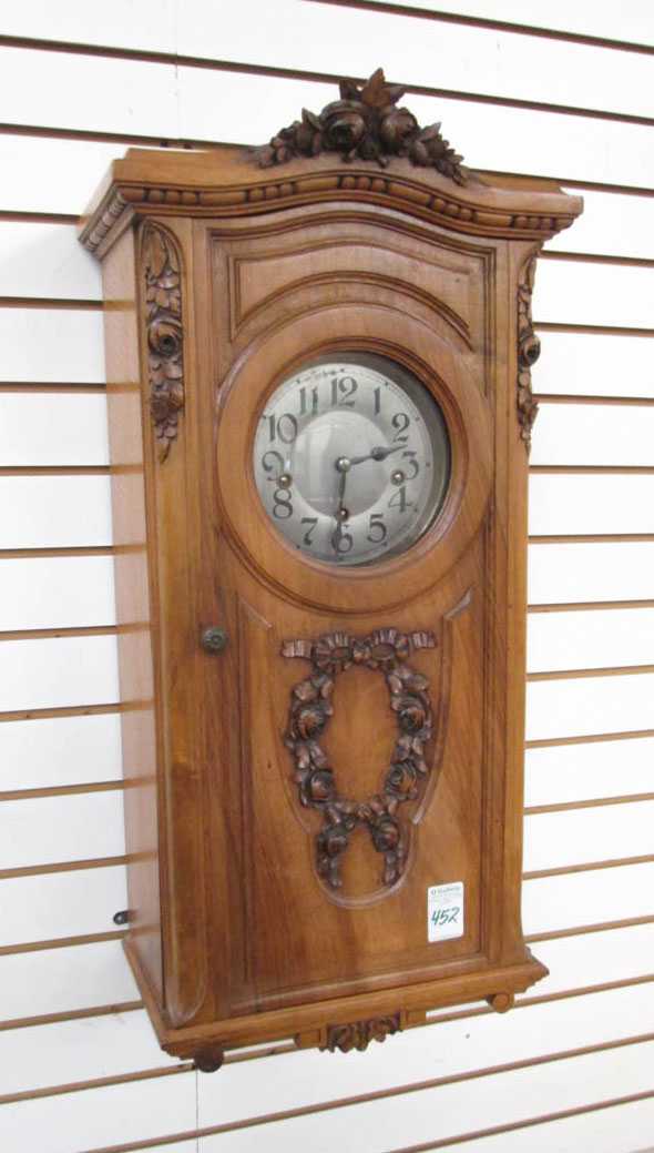 Appraisal: CARVED WALNUT BOX-CASE WALL CLOCK French early th century triple-train