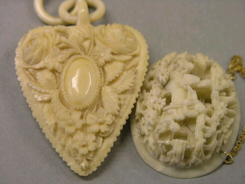 Appraisal: A carved ivory pendant heart-shaped and carved with flowers together