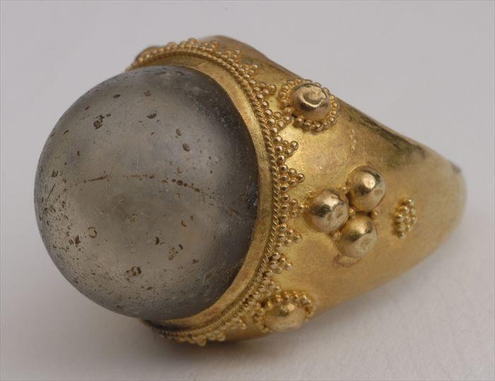 Appraisal: ANCIENT-STYLE DOMED GLASS IN A CRENELATED GOLD MOUNT Approx size