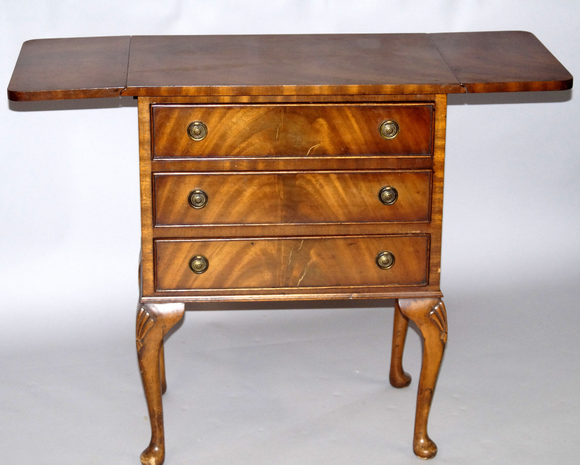 Appraisal: A mahogany drop leaf chest of three drawers raised on