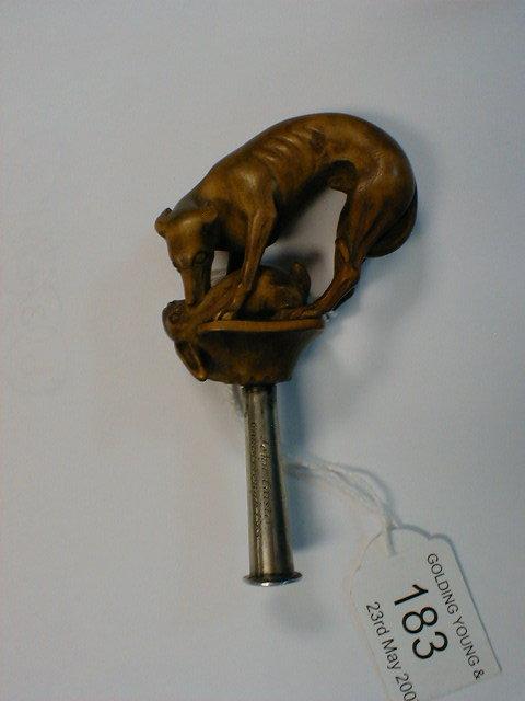 Appraisal: A pipe tamper carved as a hound with a hare