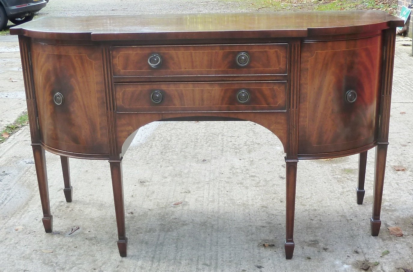 Appraisal: A reproduction breakfront sideboard fitted two drawers flanked by cupboard