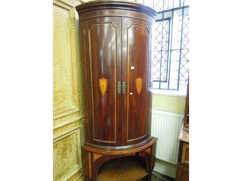 Appraisal: A Georgian mahogany bow fronted two sectional corner cupboard with