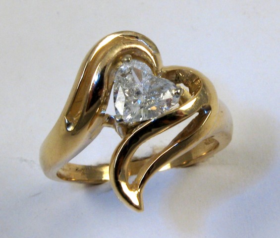 Appraisal: DIAMOND AND FOURTEEN KARAT GOLD RING set with a heart-cut