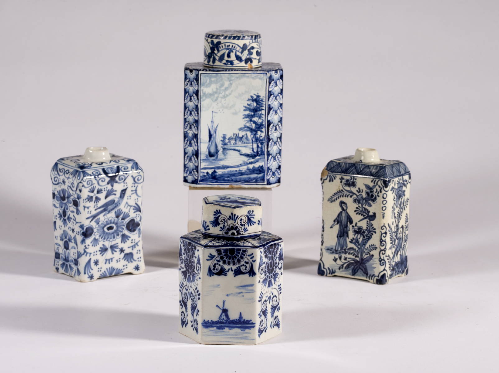 Appraisal: FOUR DUTCH DELFT BLUE AND WHITE TEA CADDIES WITH FIGURAL