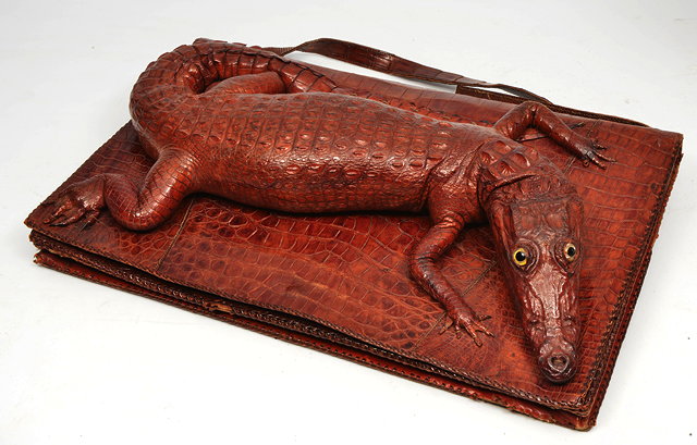 Appraisal: A CROCODILE SKIN HANDBAG the front flap mounted with a