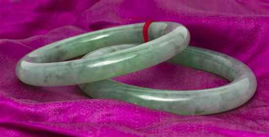 Appraisal: A Matched Pair of Jade Bangles measuring approximately mm wide