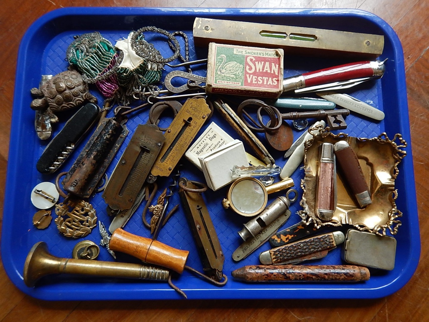 Appraisal: An assortment of pen knives balance scales military badges spirit