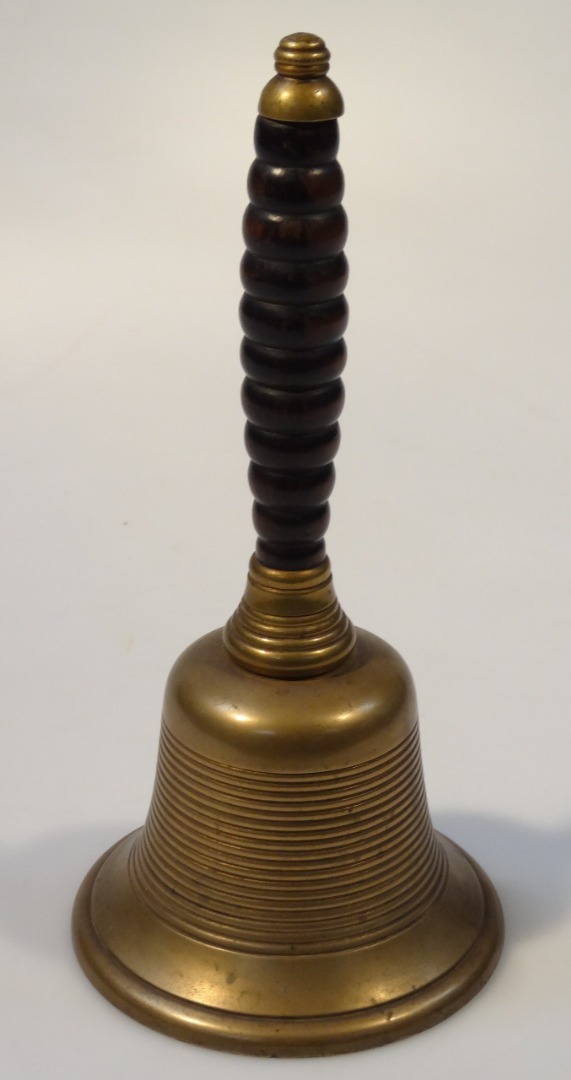 Appraisal: A brass hand bell probably thC with a turned wooden