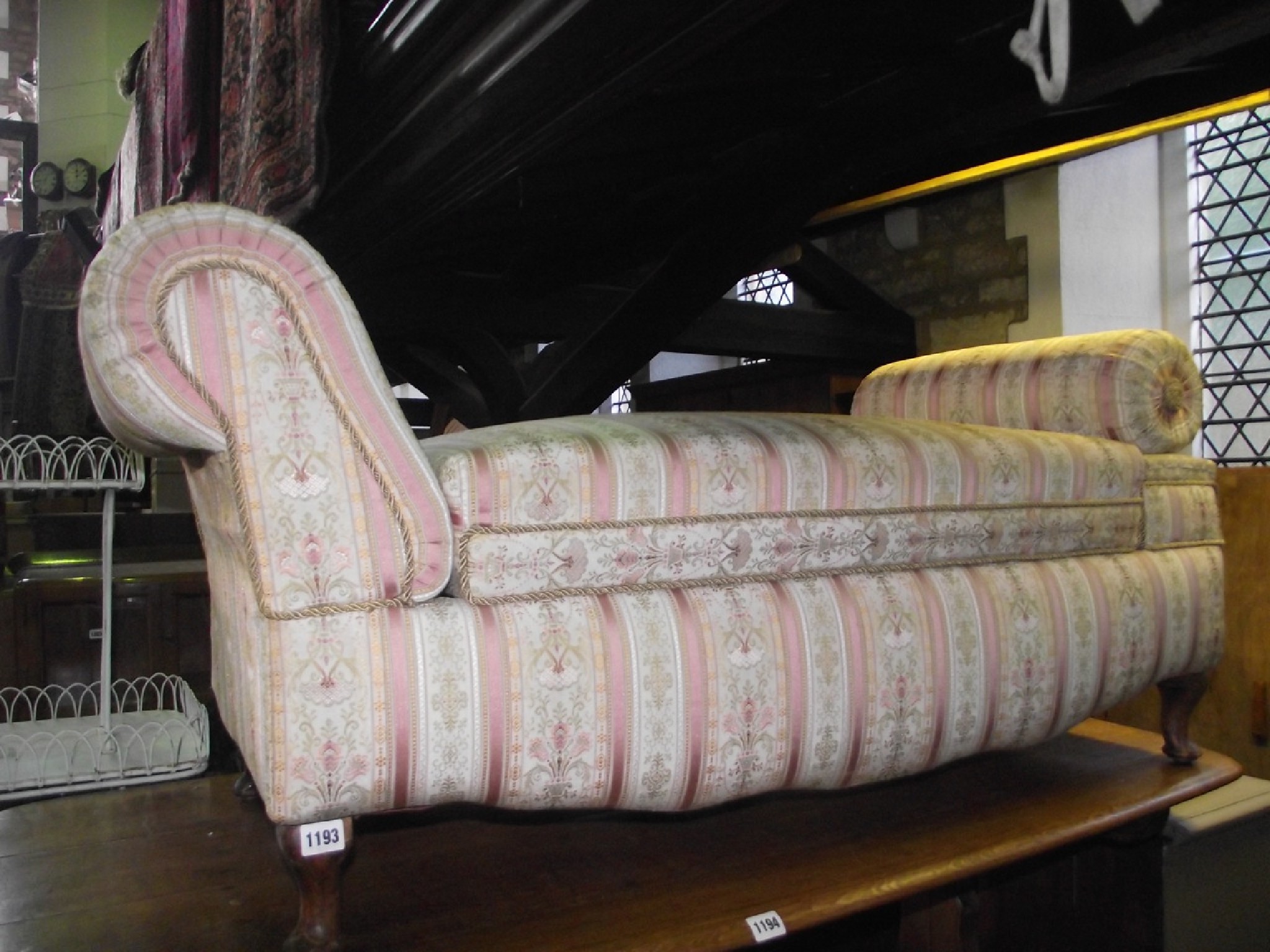 Appraisal: An Ottoman with pink striped and floral upholstery hinged box