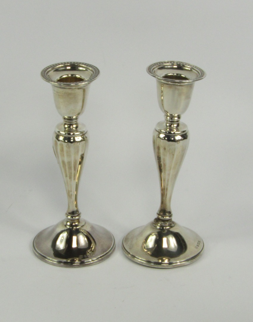 Appraisal: A pair of George V silver loaded candlesticks of baluster