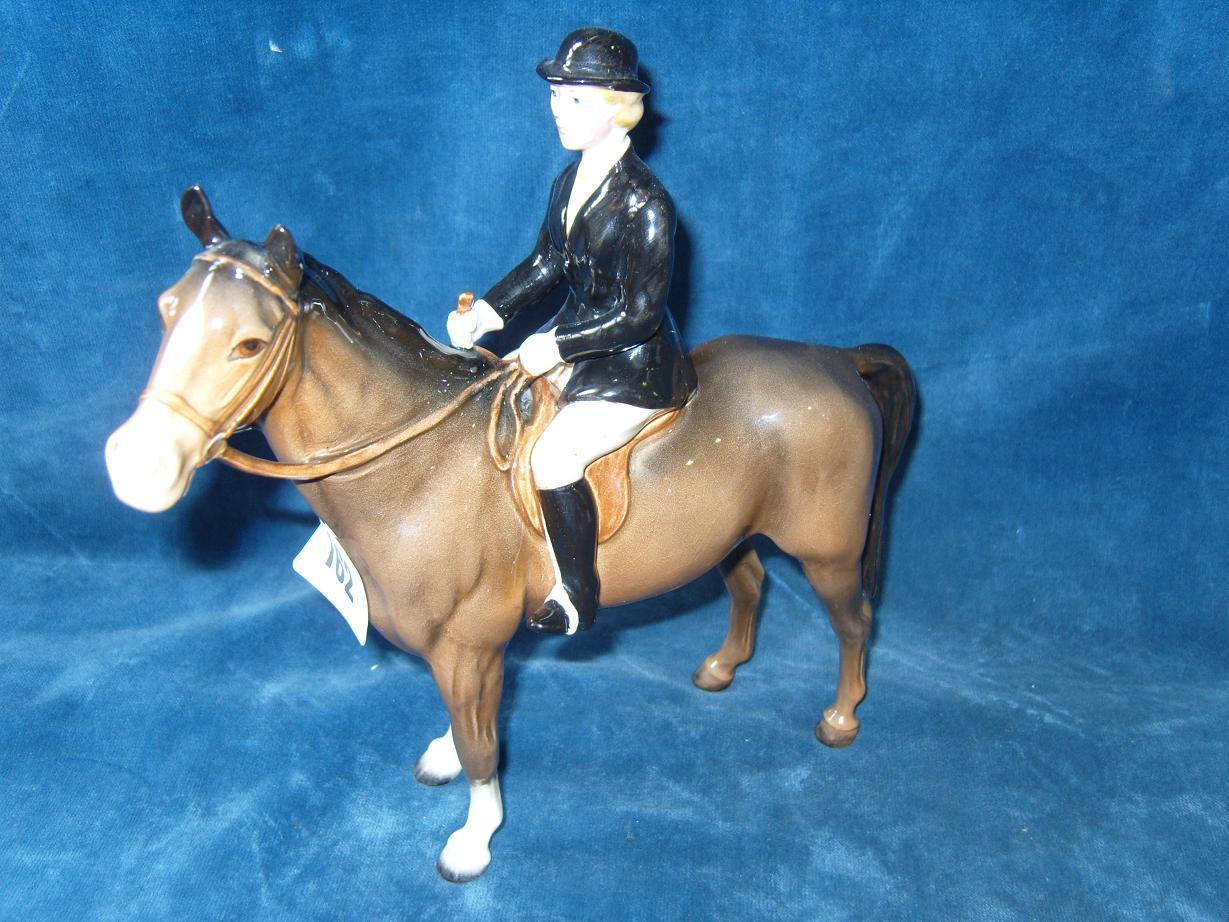 Appraisal: A Beswick model of a black jacketed huntswoman seated on