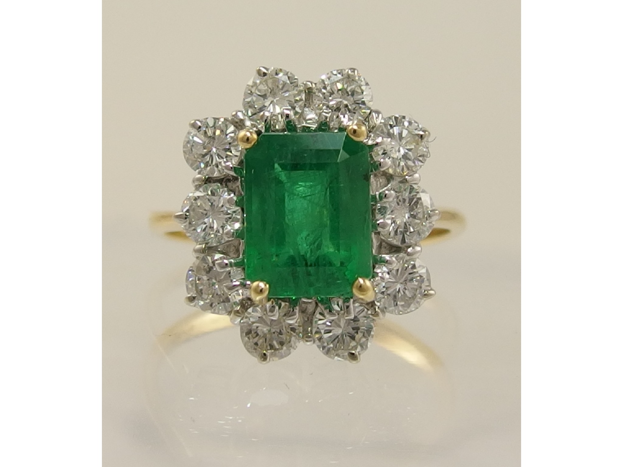 Appraisal: An ct emerald and diamond cluster ringthe step cut emerald