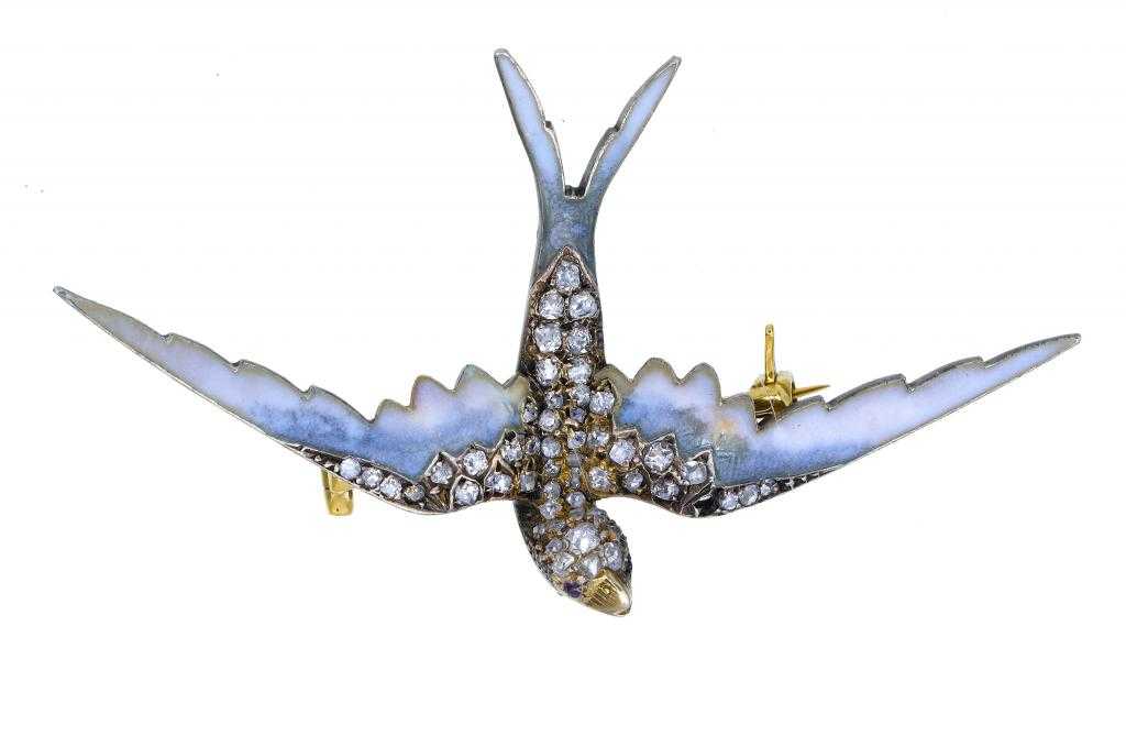 Appraisal: A DIAMOND GOLD AND TRANSLUCENT ENAMEL SWALLOW BROOCH with ruby