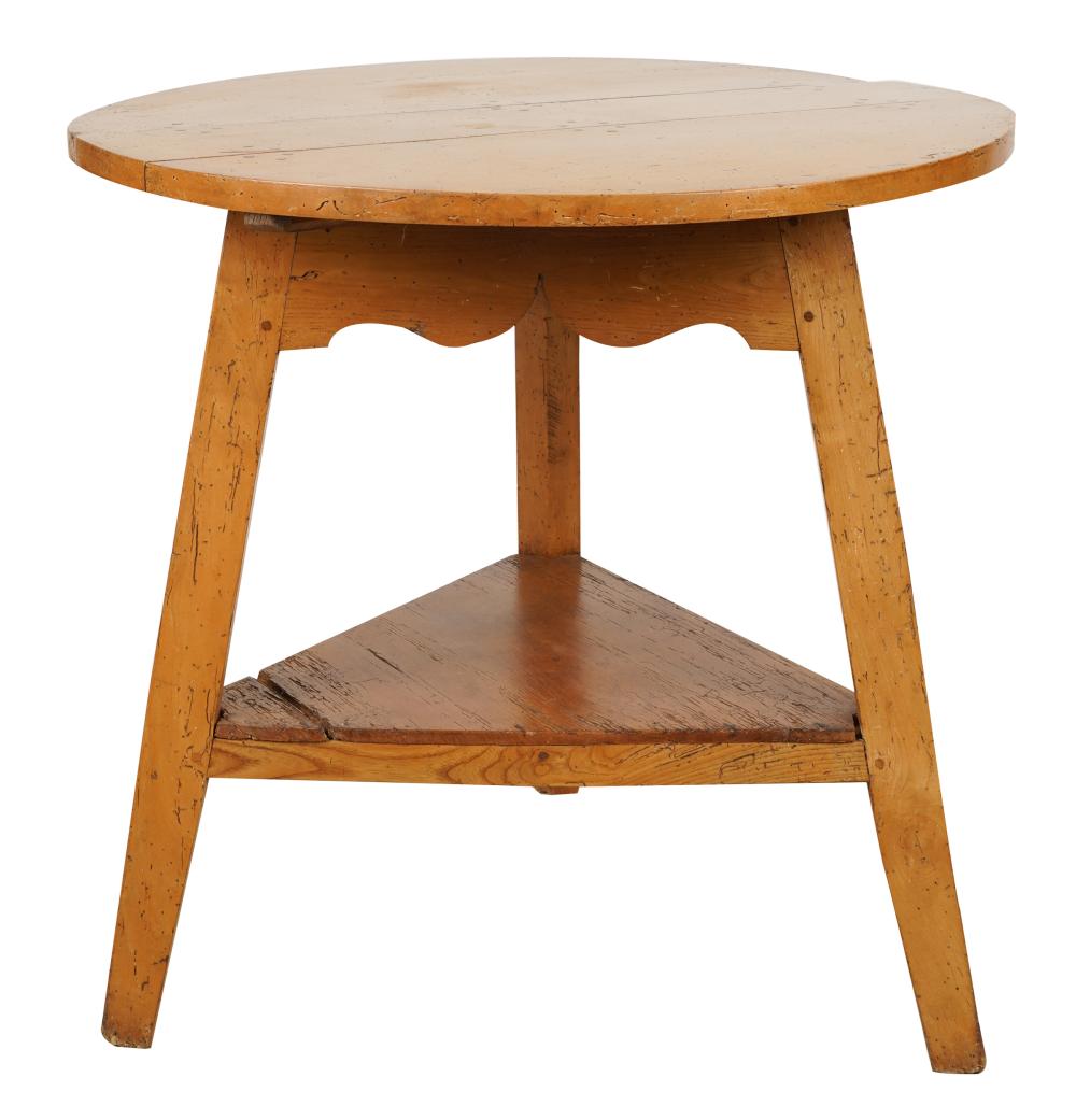 Appraisal: PINE CRICKET TABLEthe round three-plank top over a wavy apron