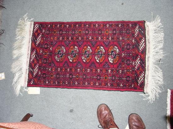 Appraisal: A SMALL PAKISTAN RED GROUND RUG with panelled decoration x