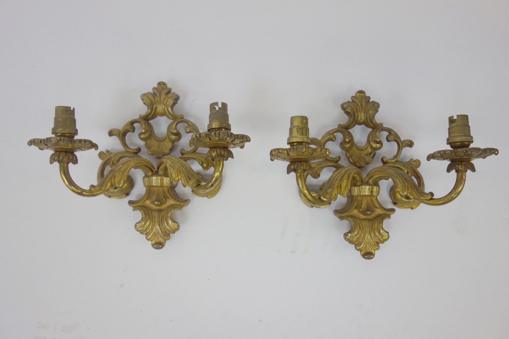 Appraisal: A pair of Rococo style gilt metal two light wall