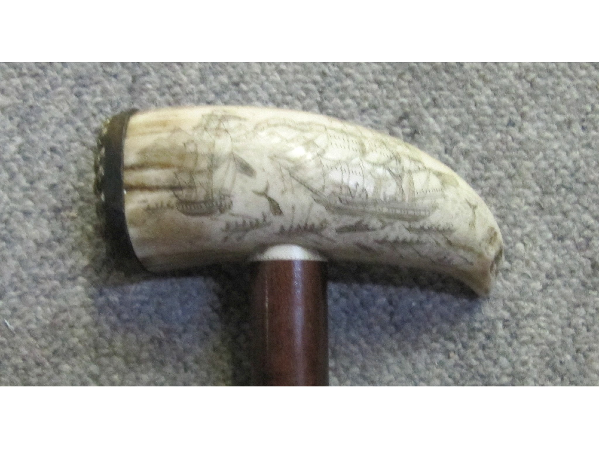 Appraisal: A walking stick with scrimshaw style handle