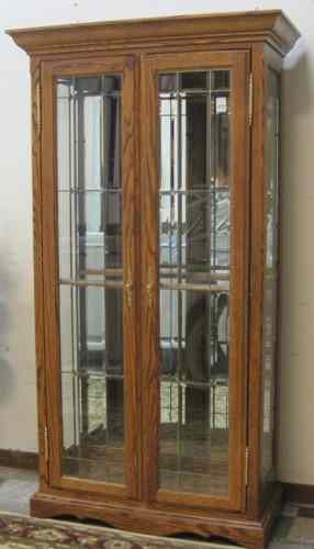 Appraisal: AN OAK LEADED AND BEVELED GLASS CURIO CABINET American th