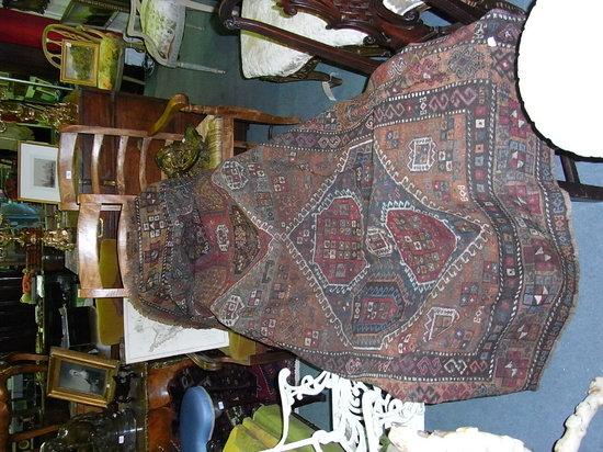 Appraisal: A SHIRAZ TYPE RUST GROUND RUG decorated with a diamond