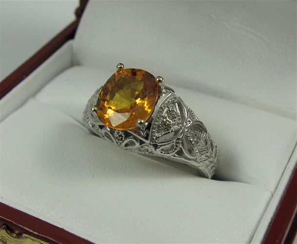 Appraisal: ORANGE SAPPHIRE DIAMOND AND K WHITE GOLD RING centering an