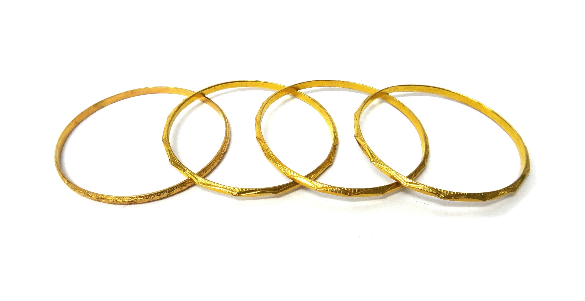 Appraisal: Four gold circular bangles having engraved decoration including three of