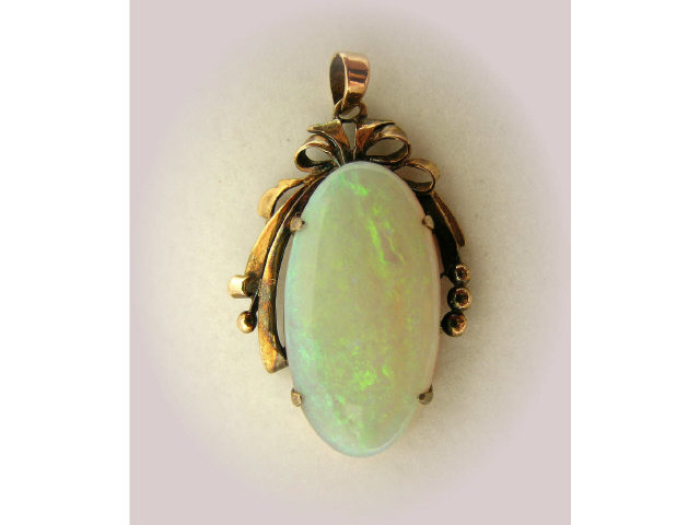 Appraisal: Large oval shaped opal pendant in ribbon motif setting