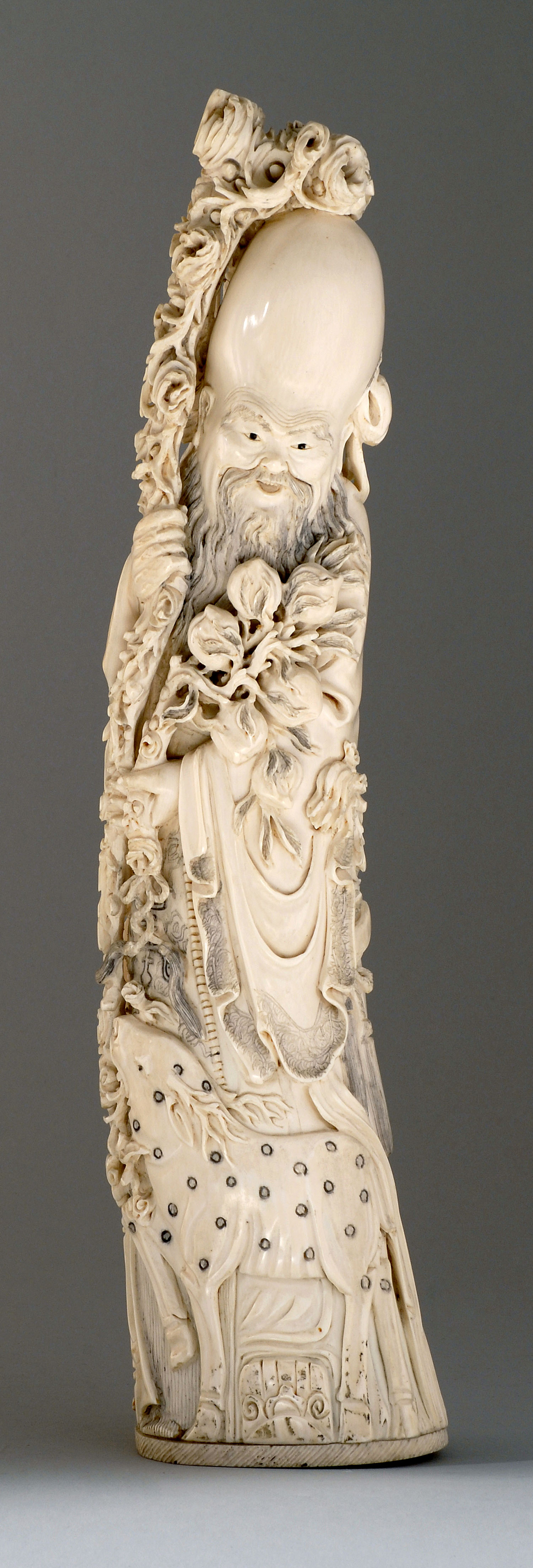 Appraisal: CARVED IVORY FIGURE OF SHOULAO Circa Standing while holding a