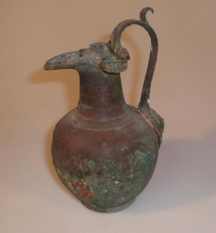 Appraisal: A Greek or Etruscan bronze oenochoe with a trefoil mouth