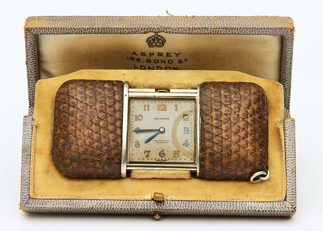 Appraisal: A MOVADO SNAKESKIN CASED TRAVELLING TIMEPIECE with sliding open closed