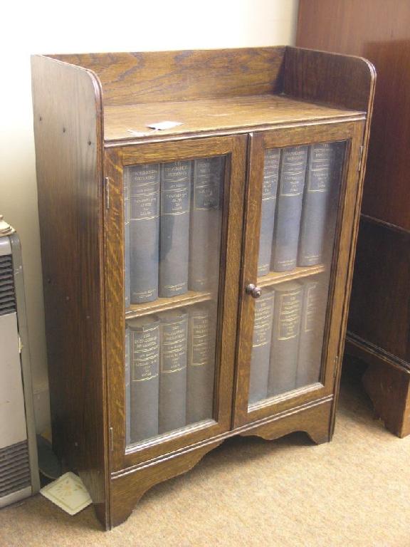 Appraisal: A solid dark oak bookcase single shelf enclosed by a