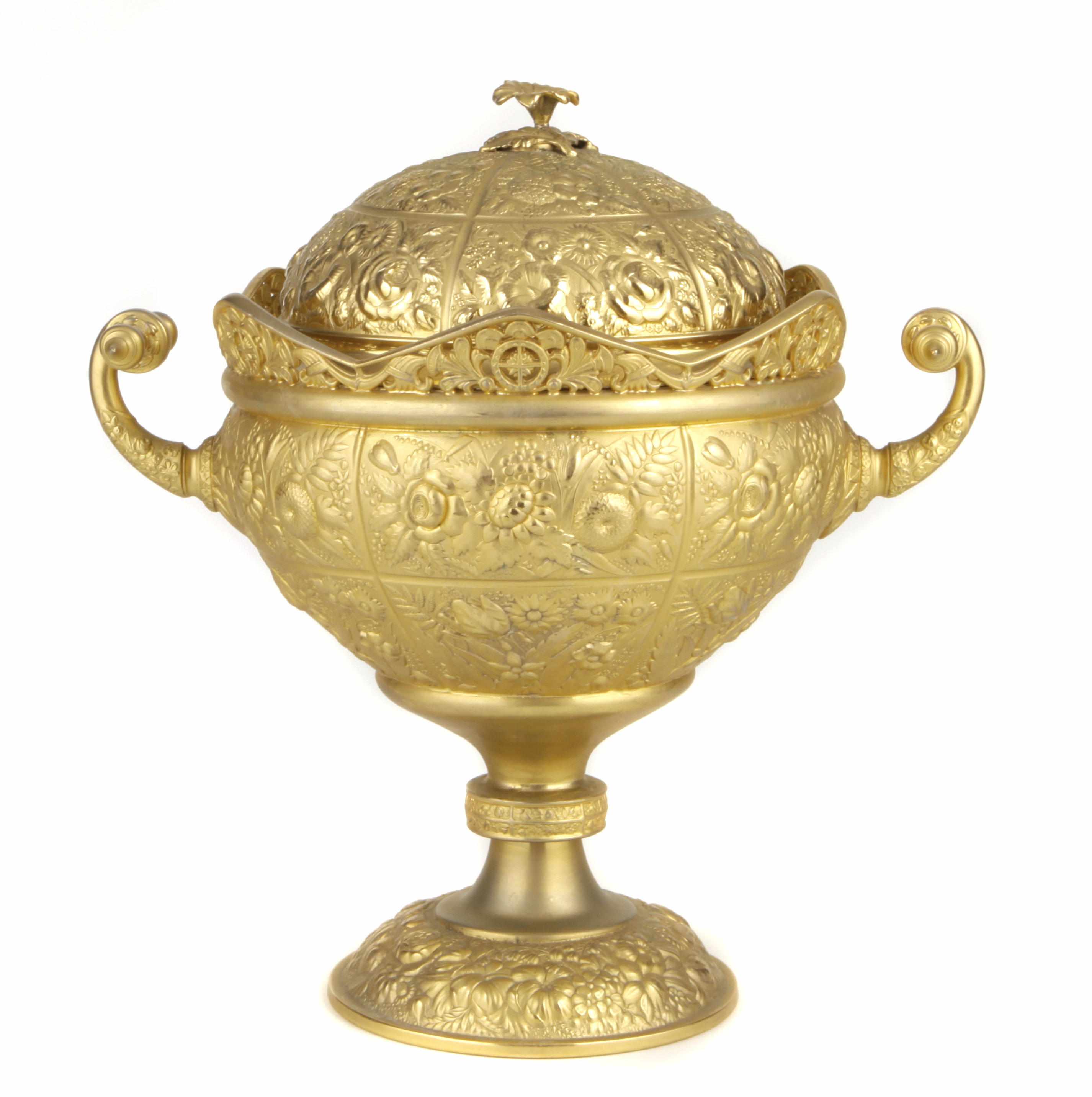 Appraisal: A gilt metal repousse decorated two handled urn height in