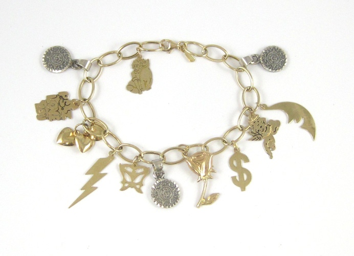 Appraisal: GOLD AND STERLING SILVER CHARM BRACELET The k yellow gold