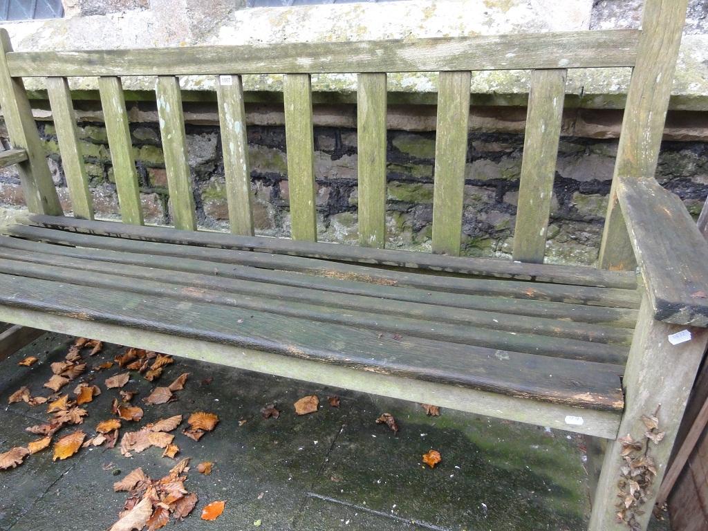 Appraisal: A weathered hardwood garden bench with slatted seat and back